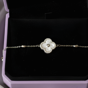 A timeless symbol of elegance, the Ivory Bloom Bracelet features a mother-of-pearl quatrefoil charm delicately framed with sparkling stones. Set on a fine silver chain, this piece is designed for effortless sophistication — perfect for daily wear or evening refinement.