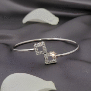 Sculpted for the modern sophisticate, the Duo Square Bangle Bracelet is a study in symmetry and refinement. Its open-ended design features two pavé-set square motifs, offering a perfect balance of minimalism and sparkle. Simple yet striking, this versatile piece is designed to slip seamlessly from daywear to evening elegance.