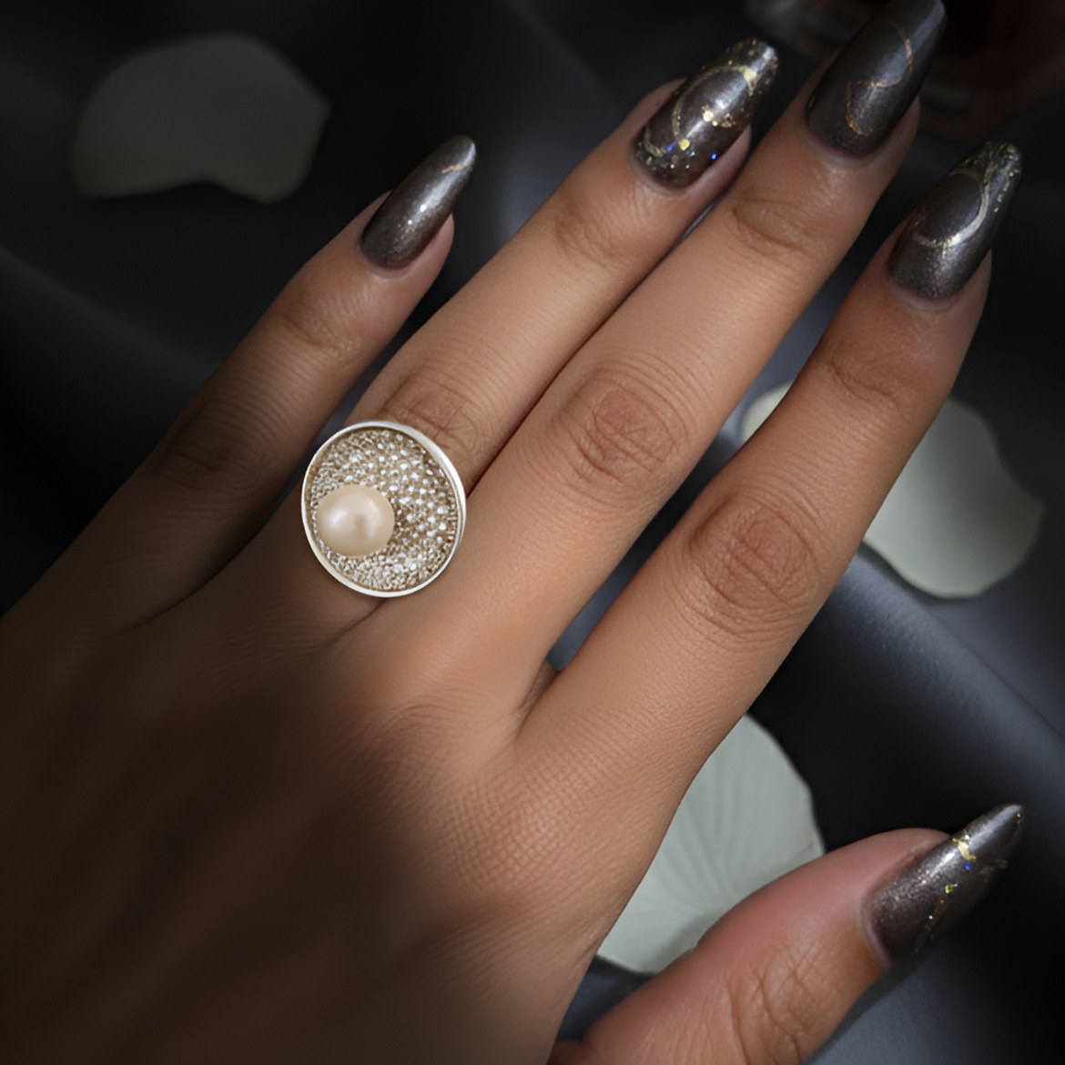 Inspired by the quiet brilliance of the ocean’s rarest jewel, Morvarid celebrates the eternal allure of pearls. Crafted in fine silver, this signature ring features a luminous central pearl set on a sculptural circular base — bold yet serene, radiant yet composed.
