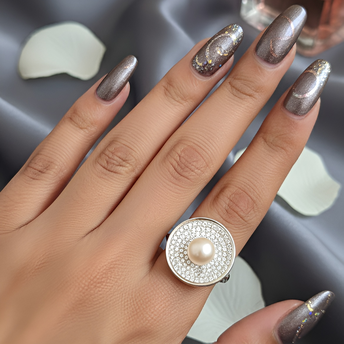 Inspired by the quiet brilliance of the ocean’s rarest jewel, Morvarid celebrates the eternal allure of pearls. Crafted in fine silver, this signature ring features a luminous central pearl set on a sculptural circular base — bold yet serene, radiant yet composed.